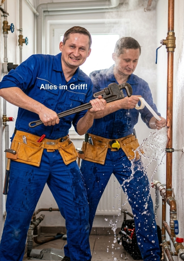 Tobias und Tobias beim verzweifelten Versuch ein massiv sprühendes Rohr mit Klebeband und einer riesigen Zange zu reparieren